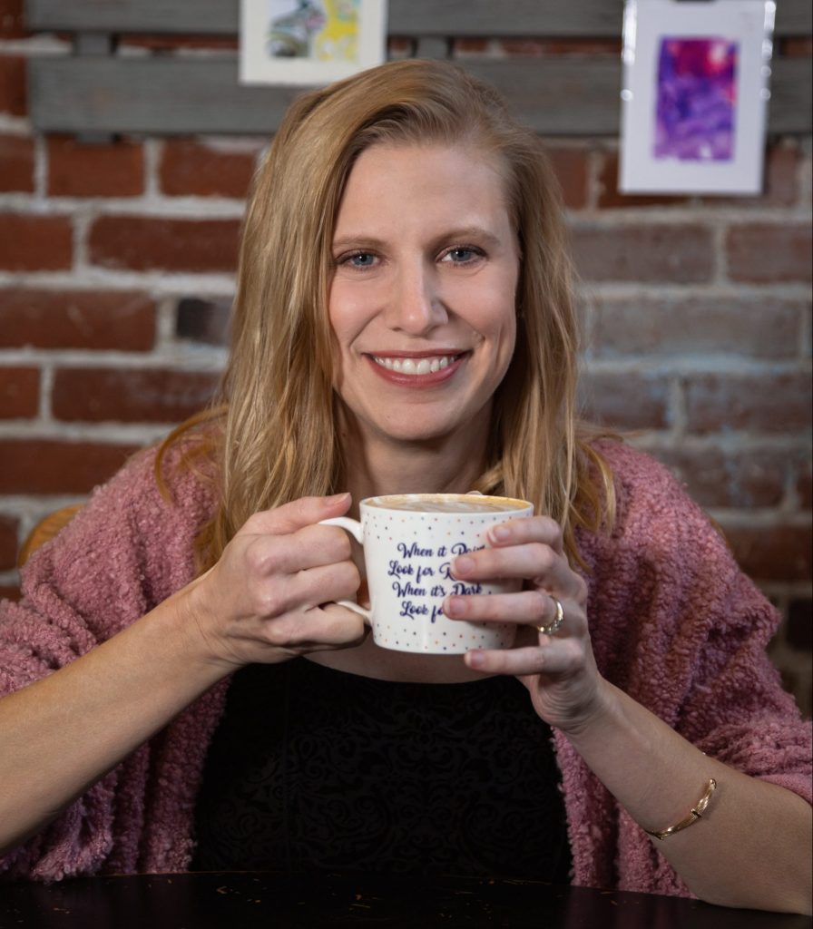 Photo of Danielle Isaac smiling with a cup of coffee.