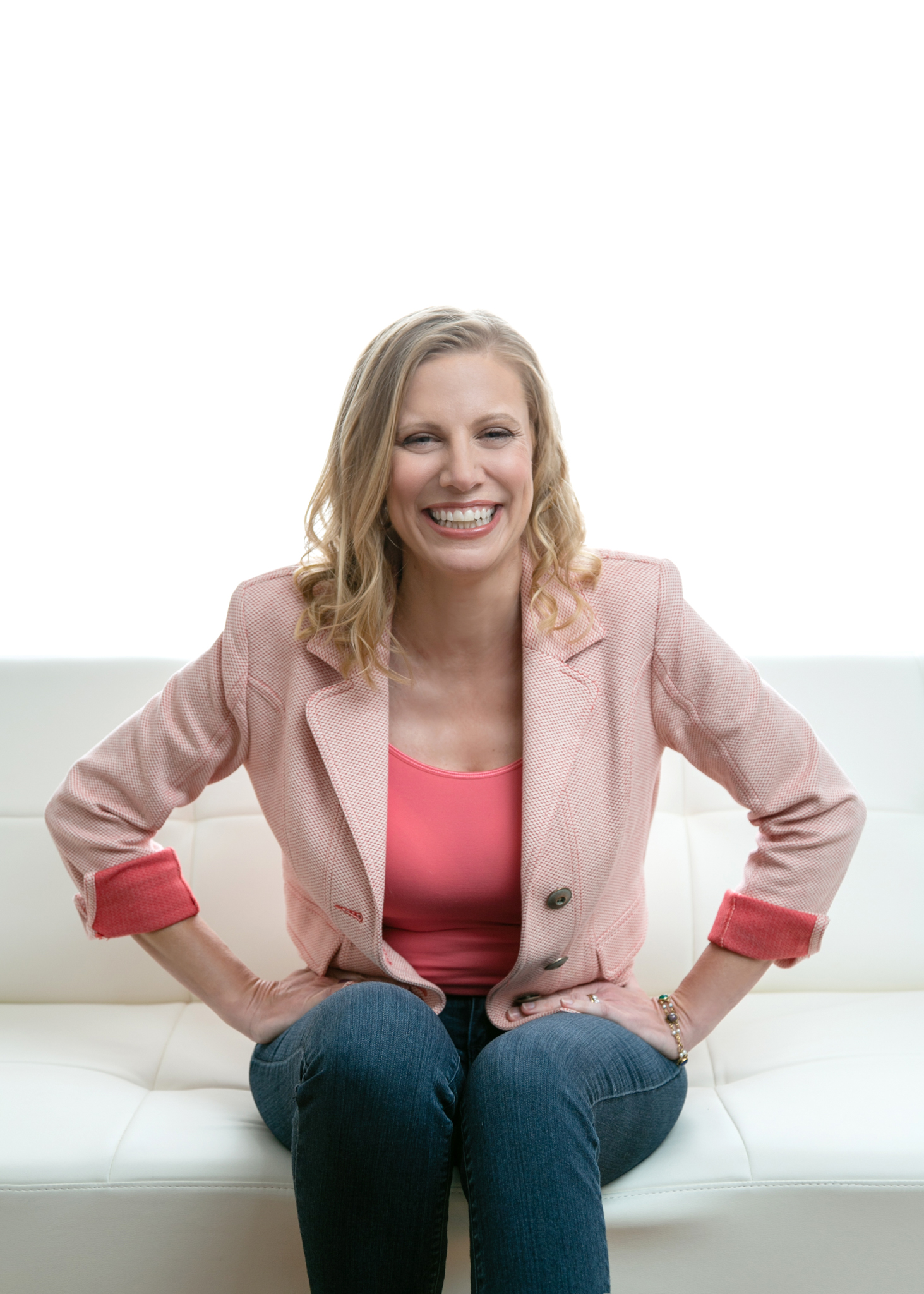Photo of Danielle Isaac, seated with hands on hips smiling straight at the camera