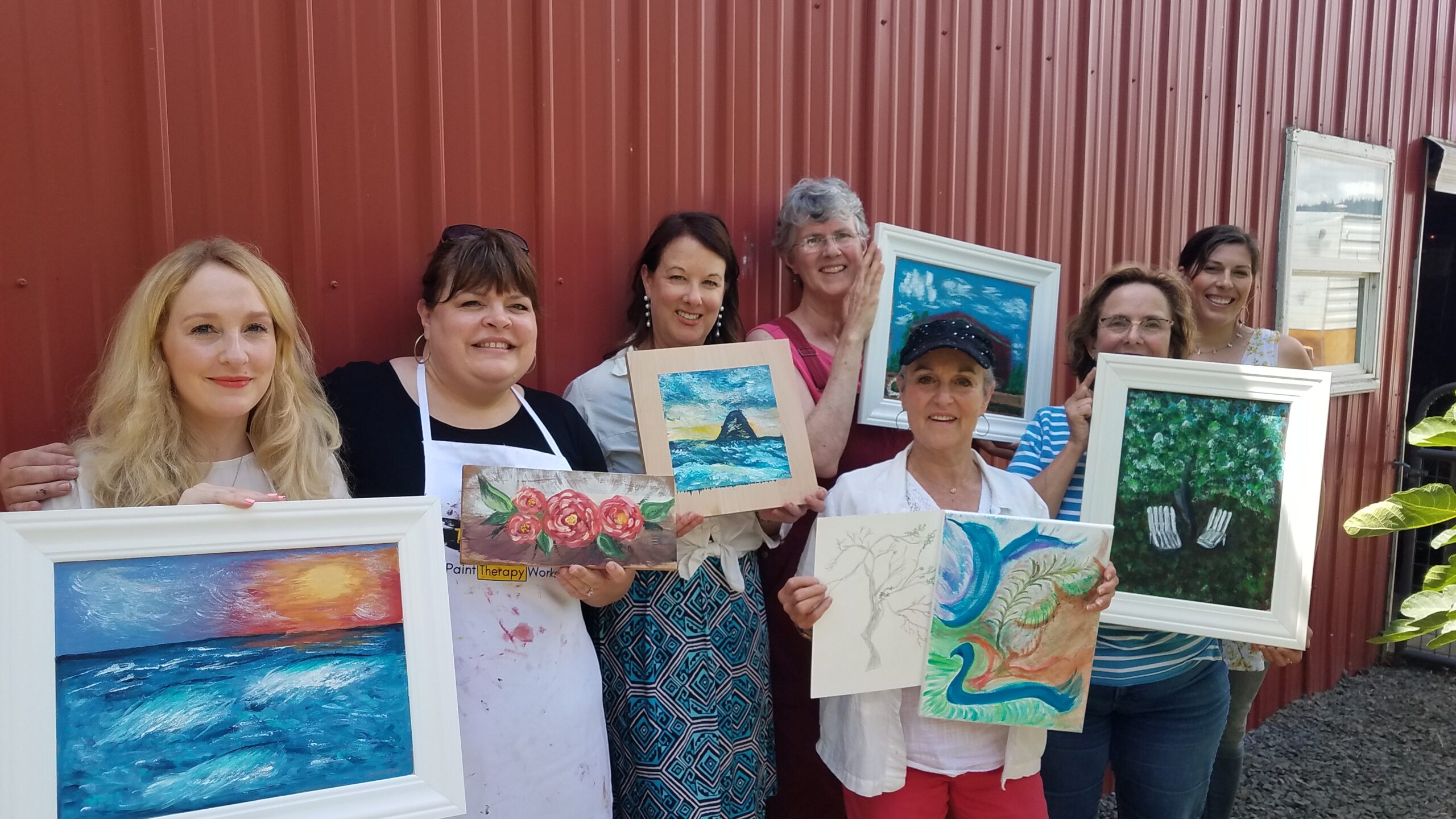 Group of women posing with their artwork painting
